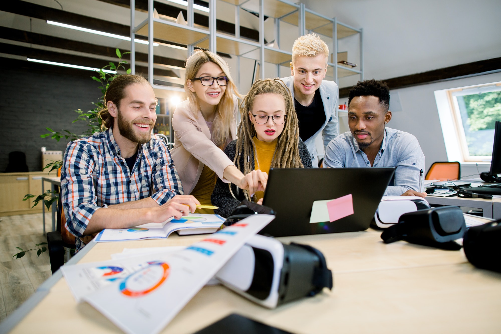 perfect-multiethnic-creative-team-group-of-five-excited-cheerful-young-people-looking-at-laptop.jpg